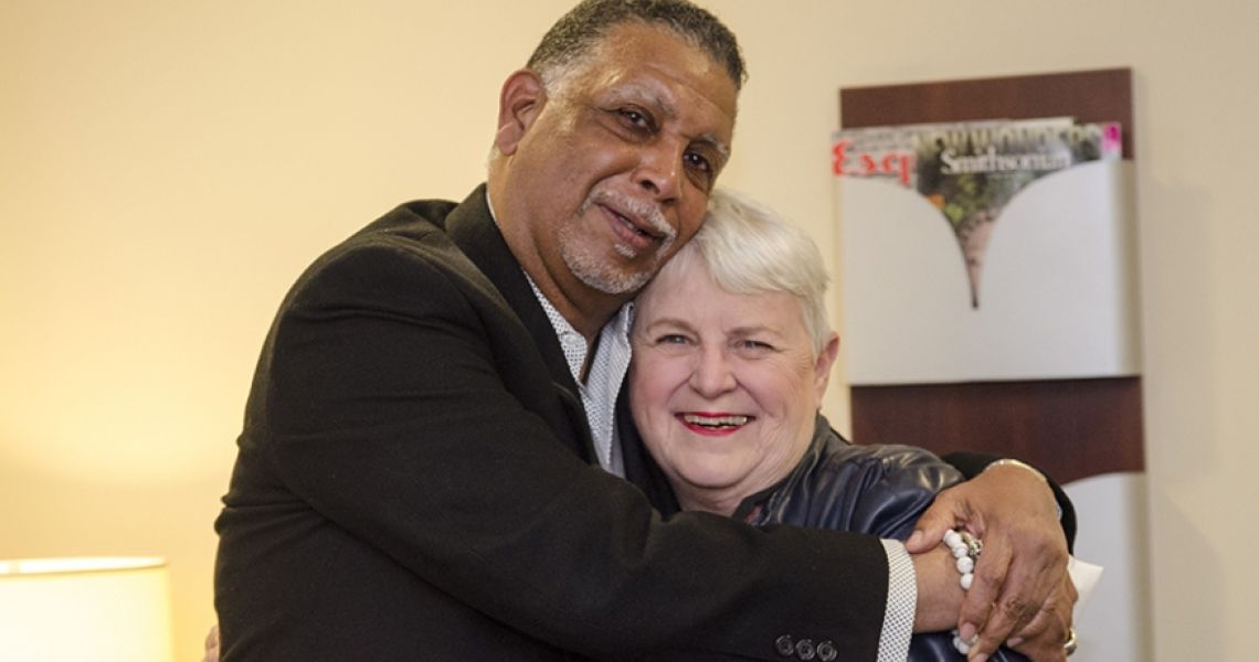 An elderly couple embracing