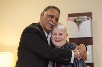 An elderly couple embracing